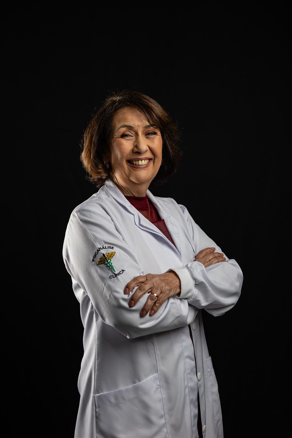 Vera Lucia Santana de Lima, sorrindo, de braços cruzados
